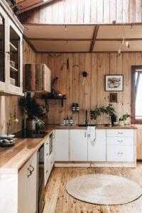 a kitchen with white cabinets and a wooden wall at Seymour House in Moss Vale