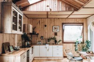a kitchen with wooden walls and a table and a window at Seymour House in Moss Vale