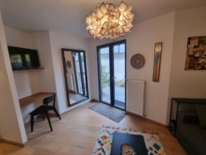 a living room with a chandelier and a table at Studio climatisé avec jardin - proche Paris in Saint-Maur-des-Fossés +5 photos