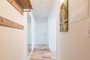 a hallway with white walls and a painting on the wall at Ferienwohnung Bonnie und Kleid in Saarburg