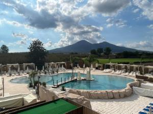 a pool with chairs and a mountain in the background at Time B&B in Poggiomarino
