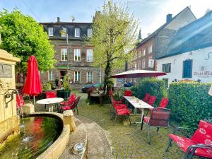 a patio with tables and chairs and a pond at Ferienwohnungen-Traben-Trarbach in Traben-Trarbach