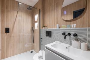 łazienka z prysznicem, umywalką i lustrem w obiekcie Unwind in Style 2BR with Cozy Backyard for Groups w Londynie