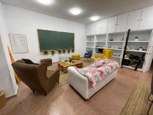 a living room with a couch and a chalkboard at Somiedoeco in Caunedo