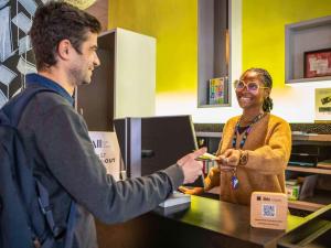 Un homme qui remet à une femme une assiette de nourriture dans l'établissement ibis Styles Paris Bercy, à Paris 37 autres photos