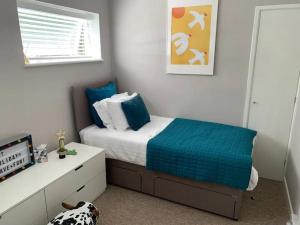 ein Schlafzimmer mit einem Bett mit blauen Laken und einem Hund in der Unterkunft Jurassic Coast Holiday Home in Charmouth