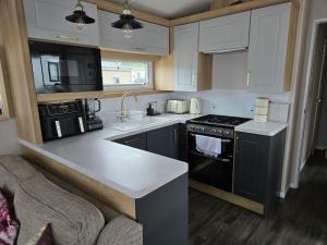 a kitchen with white cabinets and a black stove top oven at 14B Medina Rise Ferry Offers Available in Porchfield