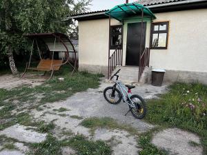 a bike parked in front of a house at Bulak - Kyrgyz Family Hostel in Karakol
