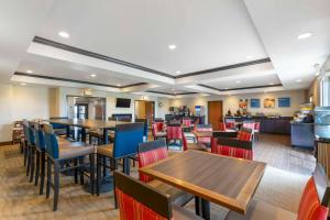 a restaurant with tables and chairs and a kitchen at Comfort Inn & Suites Grinnell near I-80 in Grinnell