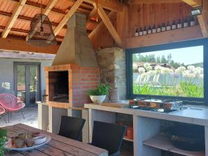 a kitchen with a brick oven and a table with a table sidx sidx at Casa Bem Estar in Mortágua