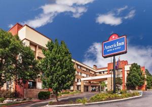 Un edificio de apartamentos con un cartel delante. en AmericInn by Wyndham Omaha, en Omaha