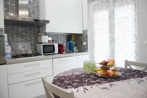 a kitchen with a table with a bowl of fruit on it at Luminose Camere a San Martino in Genova