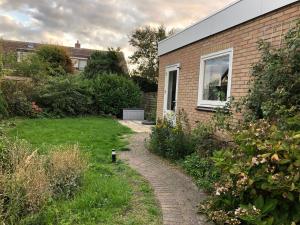 a brick house with a brick path next to a building at DeZwarteRuiter in Callantsoog