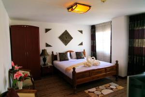 Un pat sau paturi într-o cameră la Regent Lodge Lampang