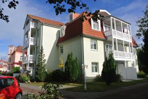 ein großes weißes Gebäude mit rotem Dach in der Unterkunft Fewo Rosenhof 03 in Kühlungsborn