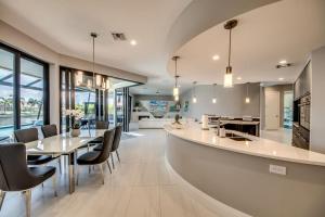 une cuisine ouverte et une salle à manger avec des tables et des chaises dans l'établissement Villa Perfection by CoralVilla- luxurious, sun deck on water, à Shell Point Village