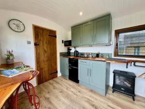 a kitchen with blue cabinets and a stove at Mooffitch Riverview Hut in Gloucester +18 photos