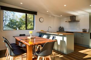 a kitchen and dining room with a wooden table and chairs at Sunny Balcony | Mountain Views | Relaxed - KK04313 in Kaikoura