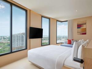 罗勇Hilton Garden Inn Rayong的卧室里有一张白色的大床和大窗户