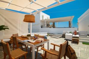 a living room with a table and chairs at Miles Away Sifnos - Beachfront House in Platis Gialos