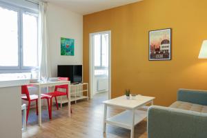 a living room with a couch and a table at Bel appartement moderne à Villeurbanne in Villeurbanne