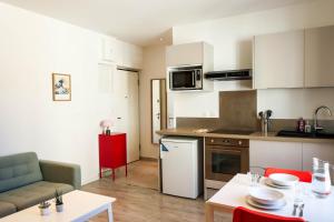 a kitchen and living room with a table and chairs at Bel appartement moderne à Villeurbanne in Villeurbanne