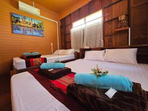 Postel nebo postele na pokoji v ubytování บ้านเรือนไทยมะลิเมืองเก่า