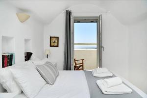 a bedroom with a white bed with a view of the ocean at Villa Ourania in Kampos Paros