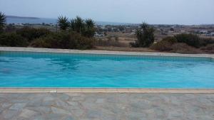 a large swimming pool with blue water at Villa Ourania in Kampos Paros