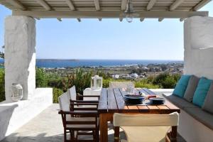a wooden table and chairs on a patio at Villa Ourania in Kampos Paros