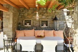 a table and chairs in a patio with a stone wall at Villa Ourania in Kampos Paros