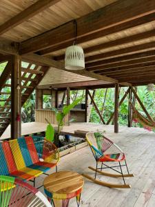 een patio met stoelen, een tafel en een plafond bij Madre Selva Eco Lodge in Nuquí +74 foto's