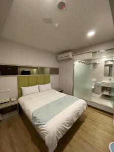 a bedroom with a large bed and a glass wall at Boutique HOTEL in Luodong