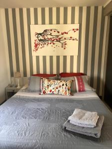 a bedroom with a bed with a striped wall at STUDIO EN AUVERGNE Le ruisseau in Saint-Priest-Bramefant