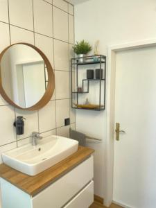 a bathroom with a white sink and a mirror at Apartment am Ronhof in Fürth