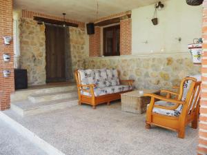 a patio with two chairs and a couch at La casa de Blas in Valoria la Buena