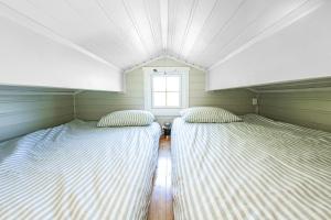 two beds in a room with a window at HeiaHytta Fredvang in Fredvang