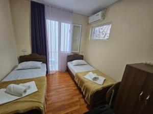 乌雷基Imeri Hotel的有两张床和一扇窗户的房间