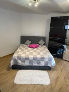 a bedroom with a bed with a pink pillow at Kłodzka 30 in Lądek-Zdrój