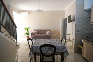 a dining room with a table and a couch at Locanda de foris apartment in Teano