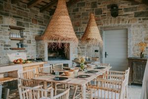 a dining room with a table and chairs and a stone wall at Luxury estate with 6 hectares land near hilltop town Motovun in Kaldir +40 photos