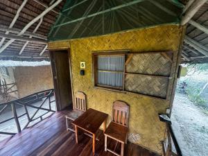 ein kleines Haus mit einem Tisch und zwei Stühlen in der Unterkunft Back Trippers Inn in San Vicente
