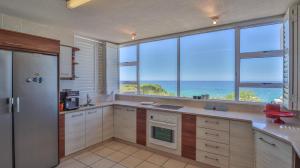a large kitchen with a view of the ocean at House Susan Pardew Hersham in Great Brak River