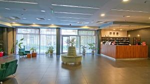 a lobby with a waiting room with plants in it at SWU Opera in Budapest