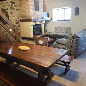 a living room with a wooden table and a fireplace at Maison de montagne, vallée d'Ossau in Bielle