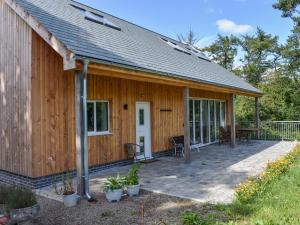 a wooden cabin with a porch and a patio at Narracott Down in South Molton