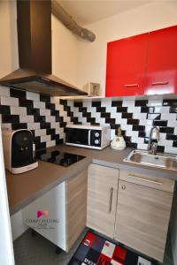 a kitchen with a sink and a microwave at Logement entier studio Gentilly in Gentilly