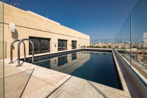 a swimming pool on the roof of a house at Palais Le Brun in Valletta