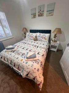 a bedroom with a bed with a comforter on it at Betty's Bungalow in Lancing