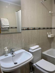 a bathroom with a sink and a toilet and a mirror at La Posada de LLanes in Posada de Llanes +11 photos
